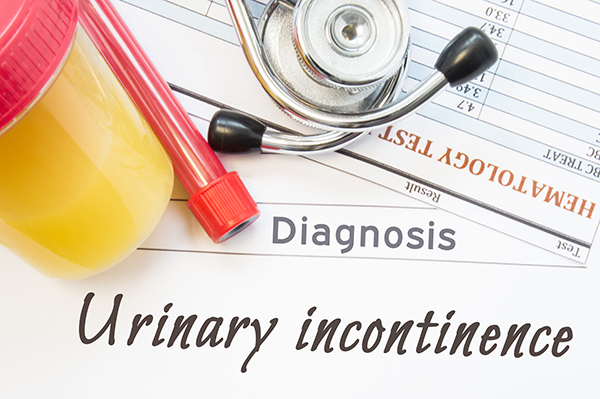 Medical testing items sitting on paperwork that says diagnosis and urinary incontinence